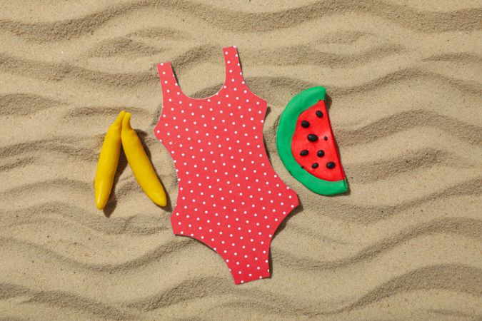 Swimsuit with fruits on the sand, recreation concept.