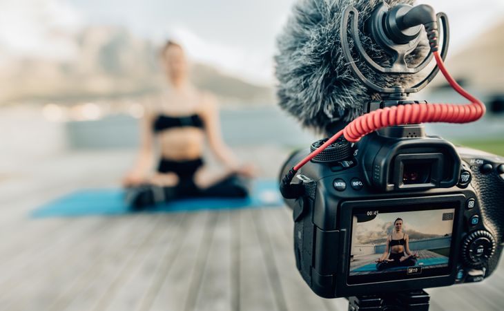 Female content creator recording yoga video for blog post