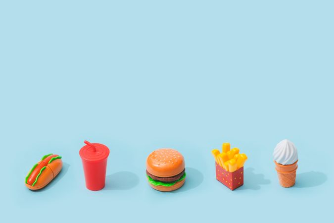 Plastic fast food items on baby blue background