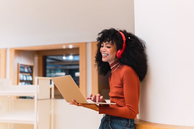 Glad female listening to music from laptop