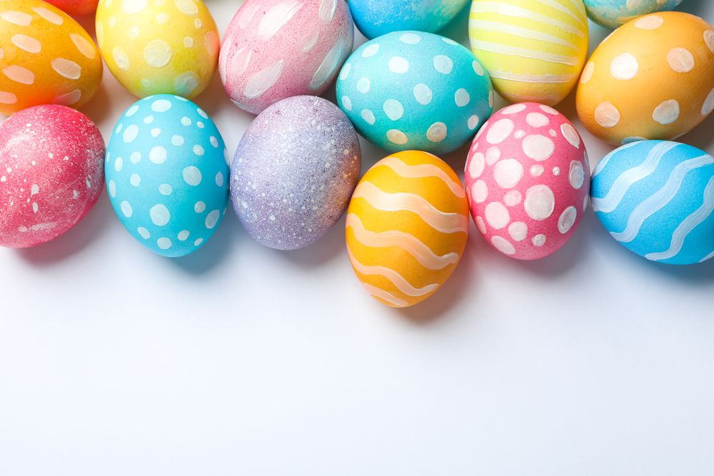 Decorative Easter eggs on neutral background, space for text. Top view