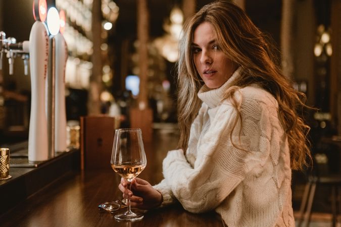 Stylish woman drinking wine in bar