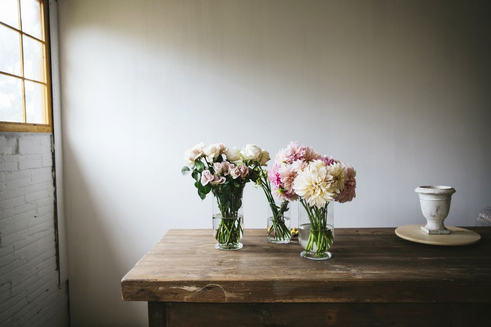 Bunches of flowers in vases on table