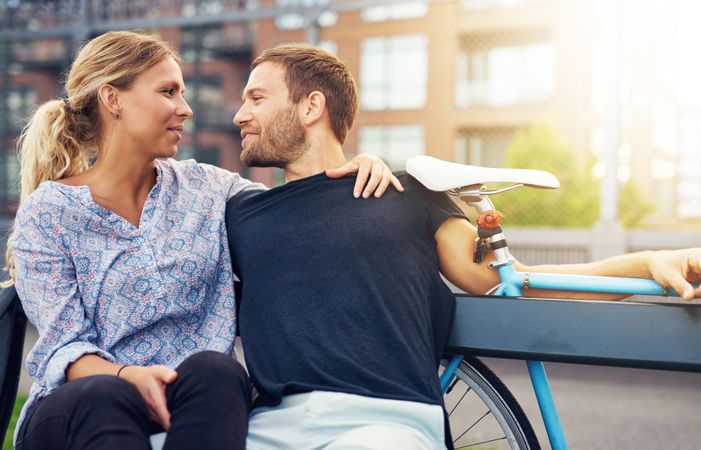 Loving couple sitting on bench in a city environment