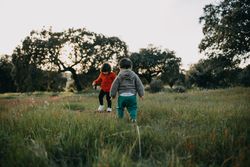 Brother and sister walking towards each other in a park