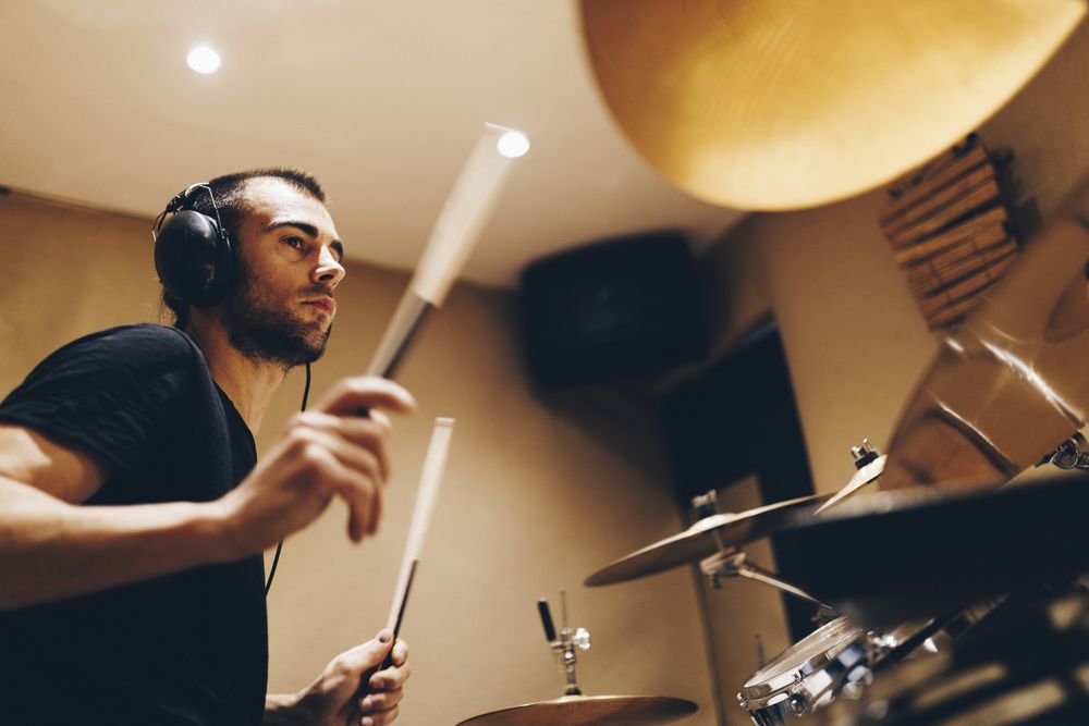 Man with headphones playing on drums