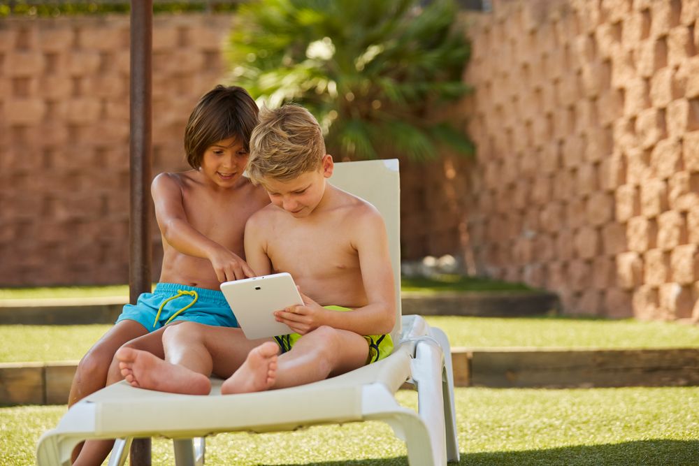 Boys using tablet in garden