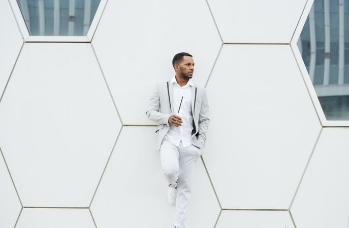 Black man with coffee standing in downtown