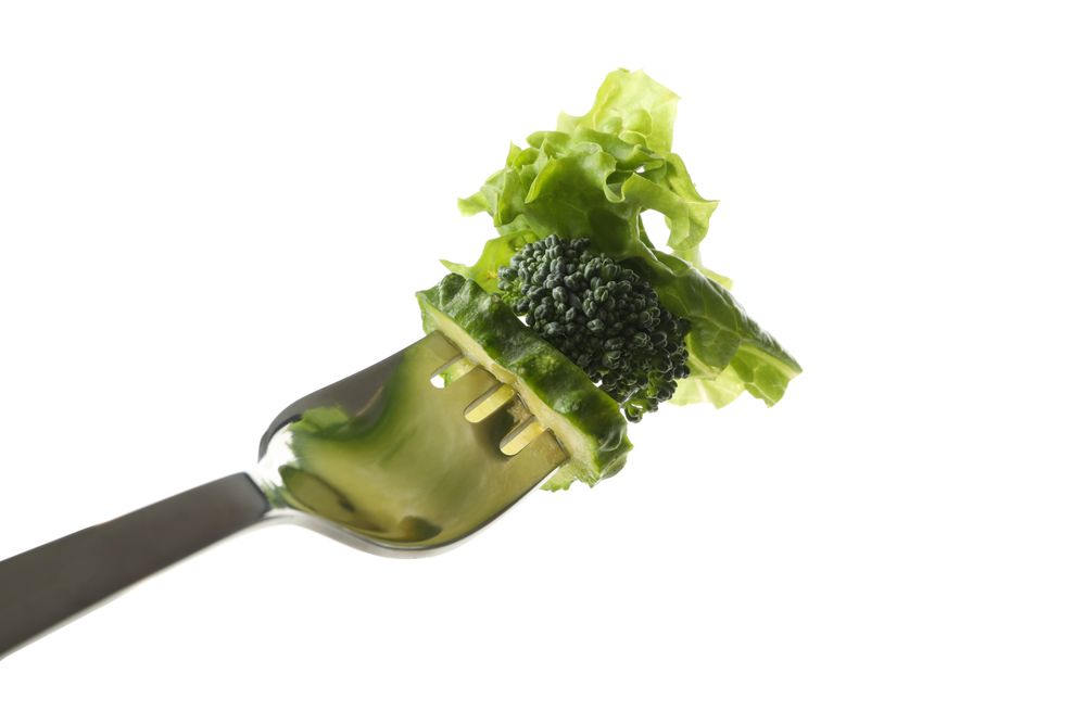 Fork with salad, cucumber and broccoli isolated on blank background