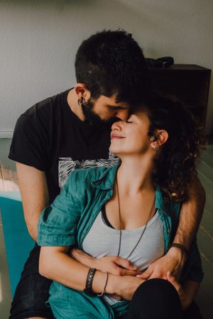 hipster couple kissing and cuddling at home