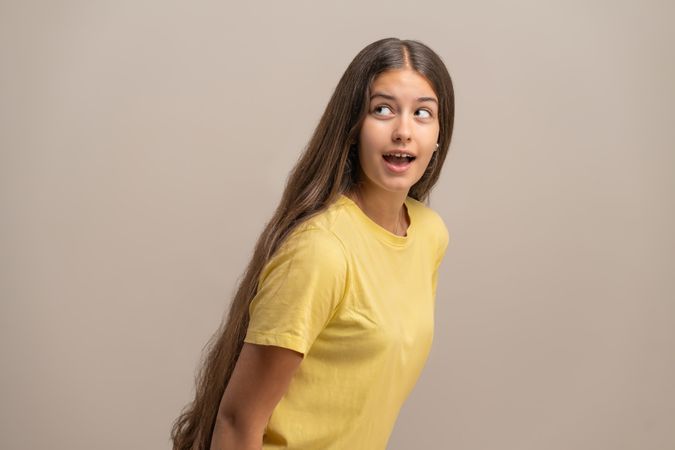 Surprised young woman with a guilty expression as if caught eavesdropping.