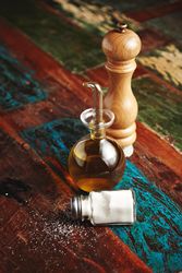 Salt, pepper and oil on wooden table