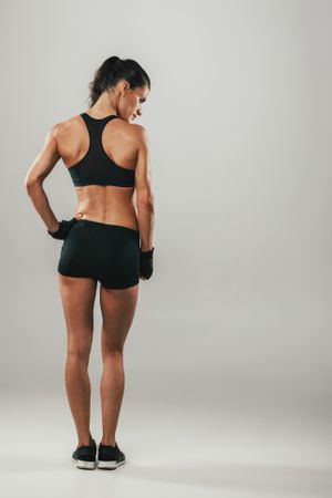 Back side view of woman in sports shorts and top
