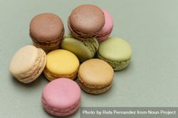 Looking down at macaroons scattered on a green table with copy space bE9QD6