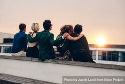 Group of friends with arms linked watching the sunset 49MRy4