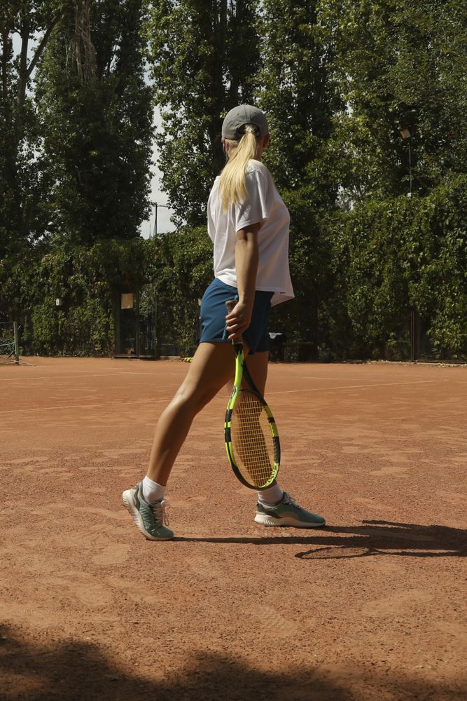 Female tennis player with racket on clay court
