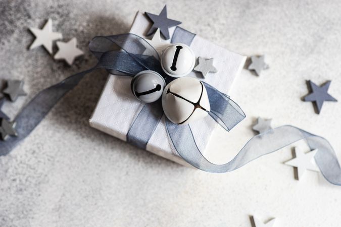 Wrapped Christmas present with bell and star ornament