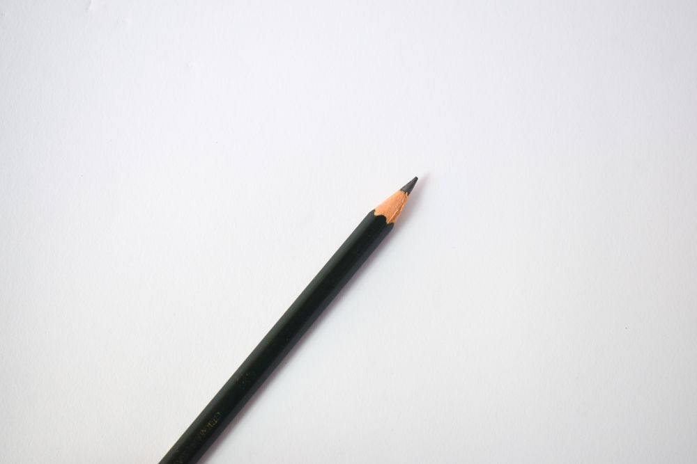 Sharpened pencil in center of table with copy space