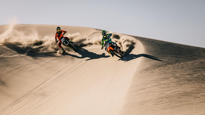 Motocross competition over dunes in desert