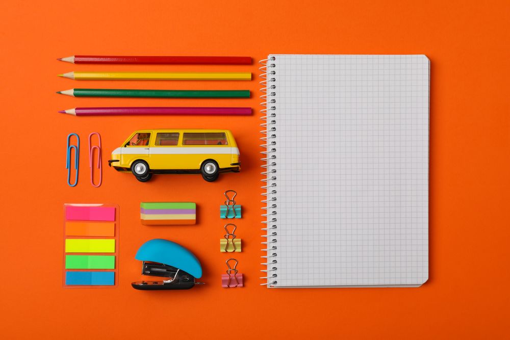 Flat lay with school supplies on orange background