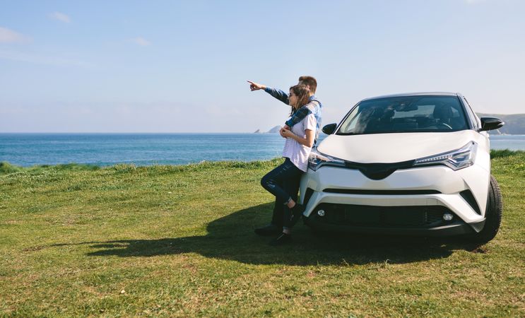 Couple with car watching landscape