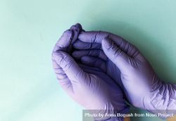 Covid-19 virus concept looking down at hands in purple latex gloves 5ngLgA