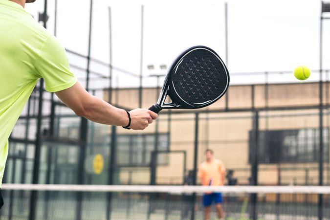 Back view of a man playing paddle tennis