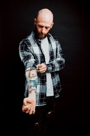 Young bald guy showing tattoos