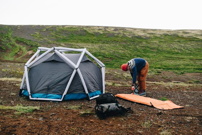 Man setting up tent in field