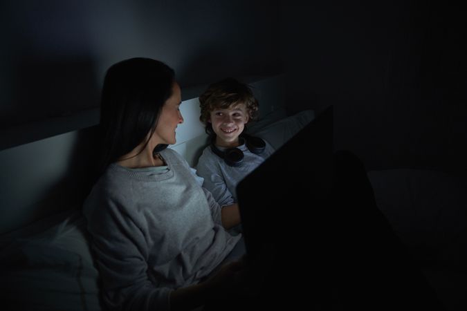 Mother and son watching movie on laptop at night