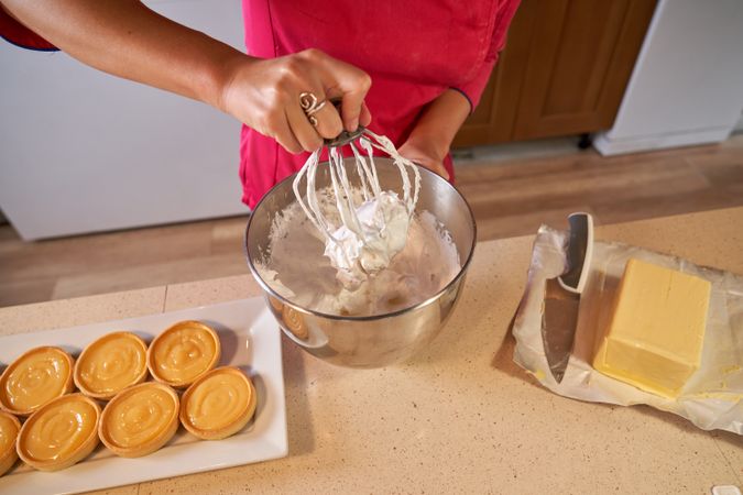 Faceless woman mixing cream in bowl
