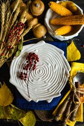 Top view of textured porcelain birds plate with rustic autumnal decor