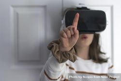 Girl wearing VR headset leaning on door 0yOxL4