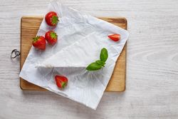 Above view of slice of cheese with strawberries