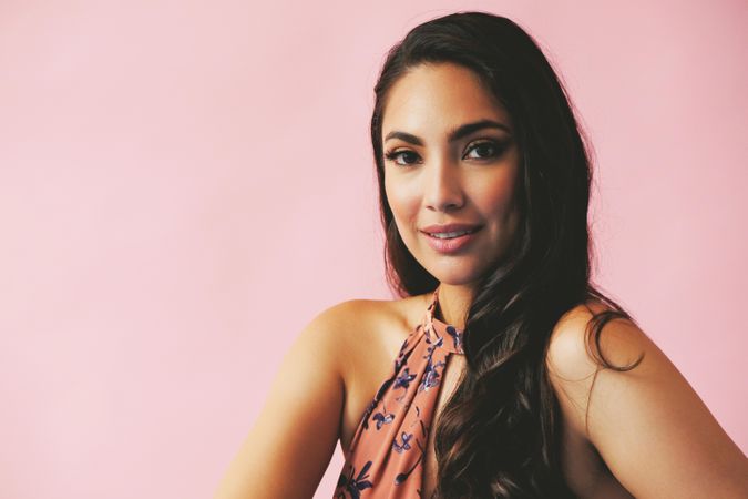 Serious Hispanic woman pictured in pink room