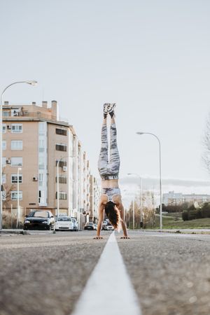 Woman doing handstand on street