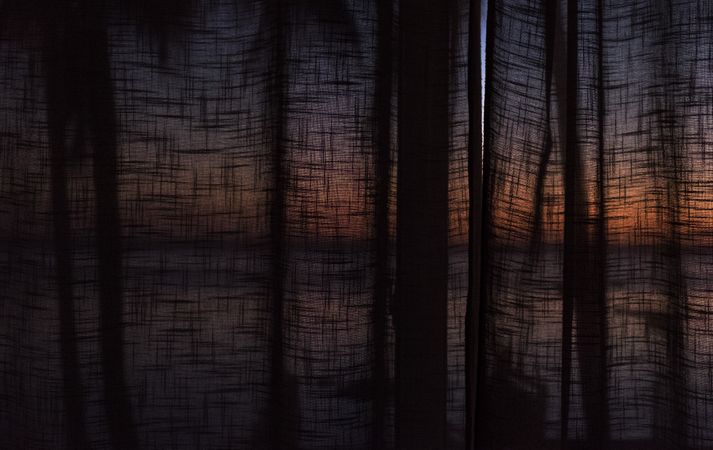 Colorful sunrise behind dark curtains