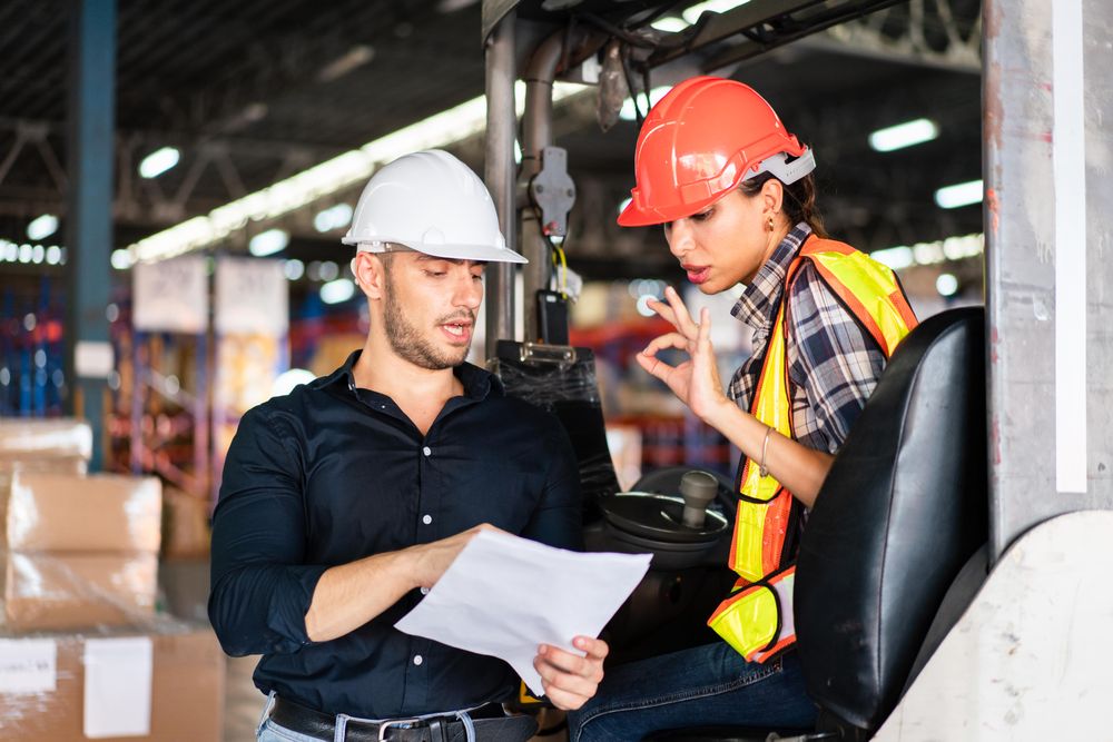 Two colleagues reviewing checklist in distribution center