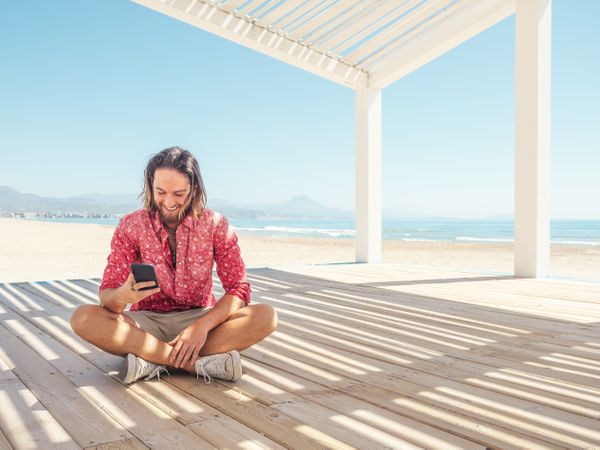 Man using smartphone on beach