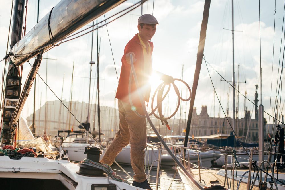 Sunset photo of captain of yacht collecting the ropes