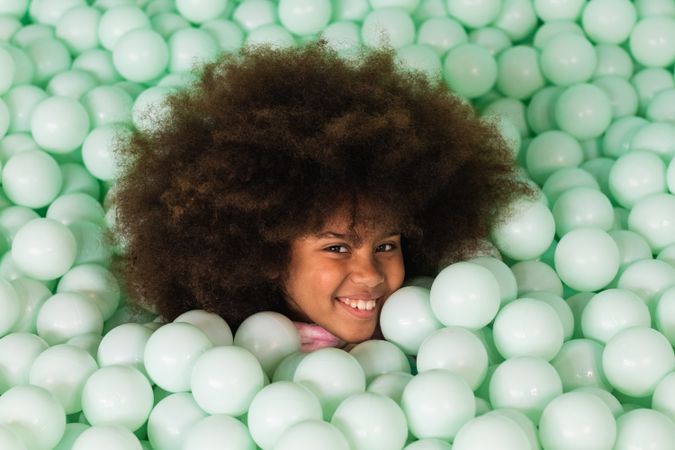 Cheerful child in ball pit