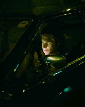 Young man smoking and driving at night