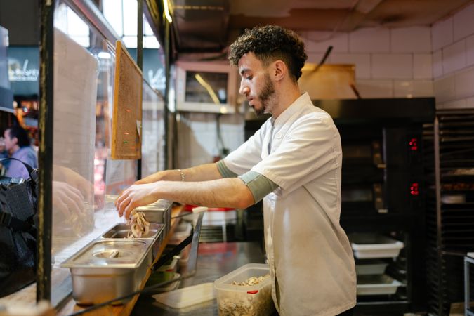 Pizza man putting ingredients in containers