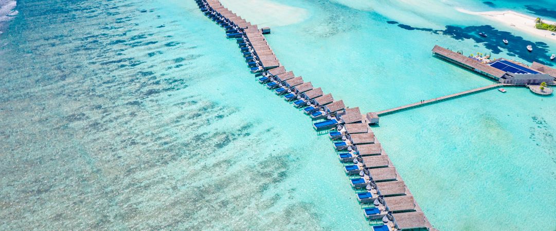 Overhead wide shot of a row of overwater bungalows in the Maldives, wide