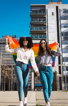Interracial female couple with LGBT flag