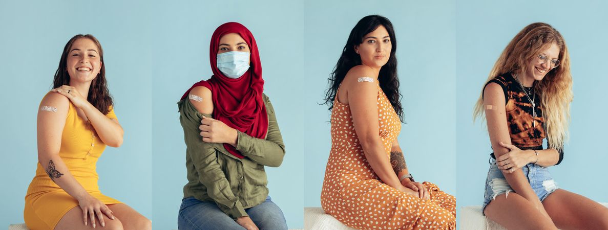Multi-ethnic females showing arm with bandage after receiving vaccine