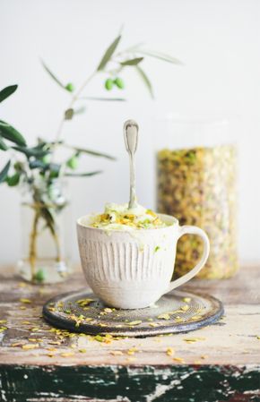 Cup of pistachio ice cream with spoon sticking upright