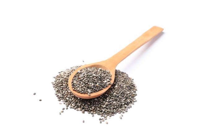 Chia seeds and wooden spoon isolated on blank background