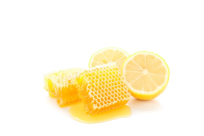 Pieces of honeycomb and lemon isolated on blank background