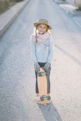 Stylish girl with skateboard on street
